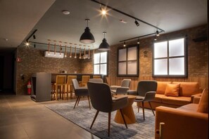 A modern interior with a dining area, sofas, and pendant lighting. - VN Consolação (São Paulo)
