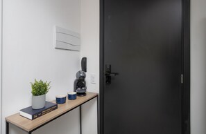 Una cocina moderna con una cafetera, una planta en maceta y un libro sobre la encimera.
