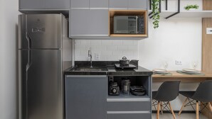 Una cocina moderna con un refrigerador de acero inoxidable, un microondas y una cafetera integrada.