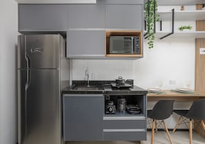 A modern kitchen with a stainless steel refrigerator, a microwave, and a built-in coffee maker. - VN Consolação (São Paulo)