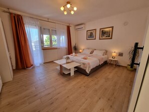 Een slaapkamer met een bed, nachtkastjes, een bureau en een raam met gordijnen.