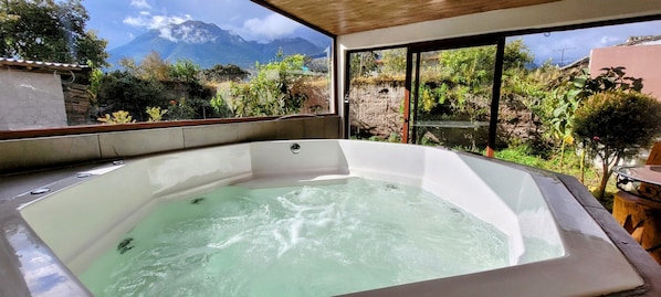 Un jacuzzi con vista a montañas y follaje.