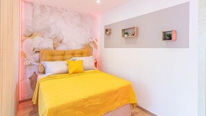 A bedroom with a bed, a headboard, and wall-mounted shelves with plants. - Le 182 Promenade du Soleil, Tout Juste Rénové, Azur Riviera (Menton)