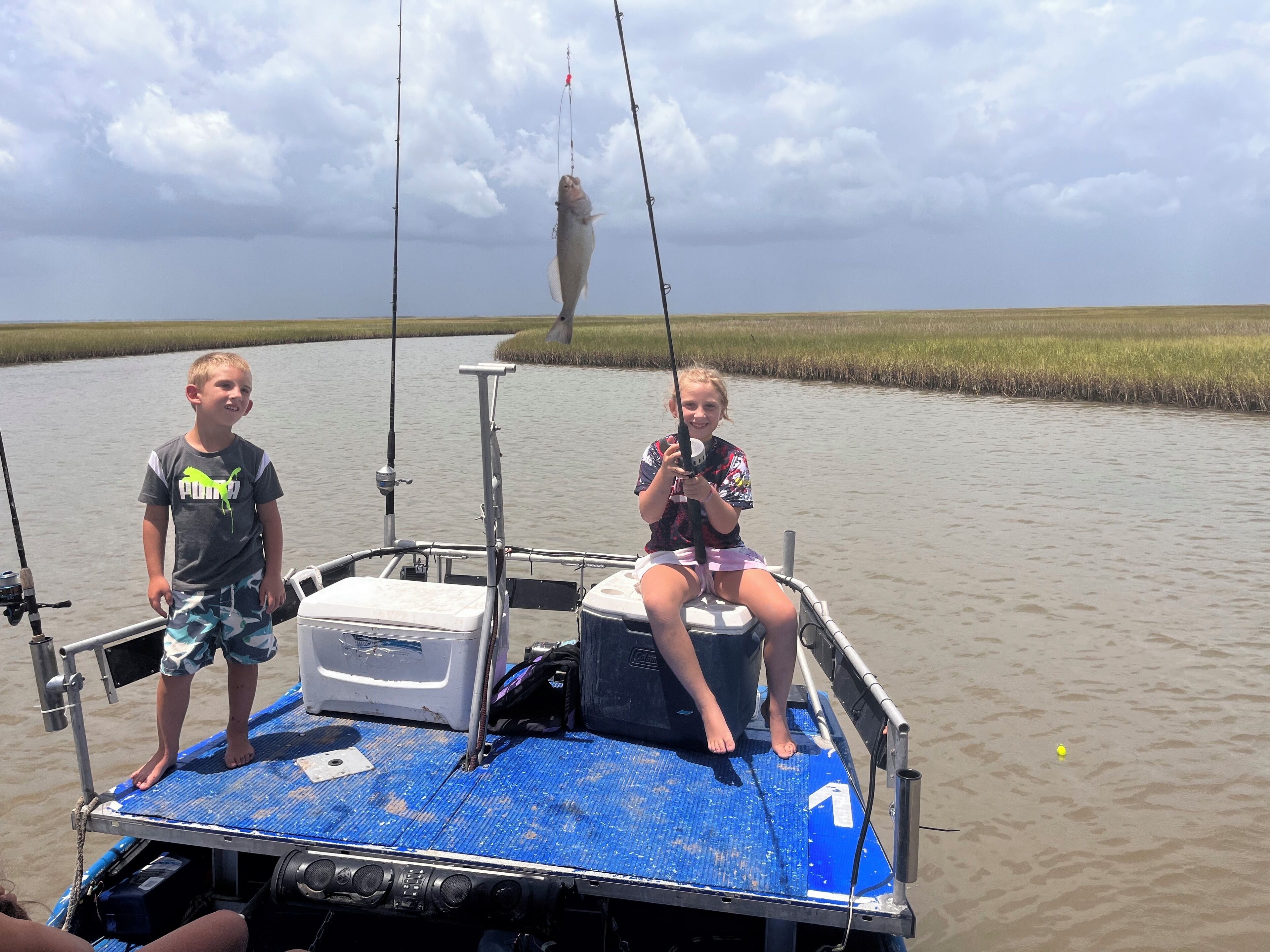 Ein Boot mit zwei Anglern, einer Kühlbox und Angelruten.