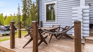 A wooden deck with a rope barrier, a table, and chairs. - Kuusipirtti by Interhome (Puolanka)