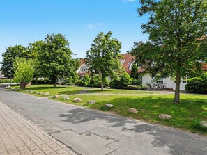 Una calle residencial con casas, árboles y una carretera pavimentada.