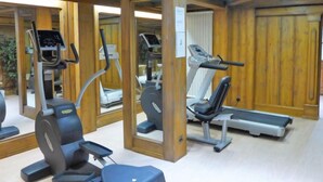 Une salle de sport équipée de matériel d’exercice, notamment des tapis de course, des appareils elliptiques et des bancs de musculation.