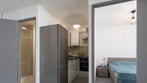 A compact kitchen with a refrigerator, oven, and sink.