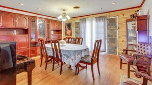 A dining area with a round table, wooden chairs, and a chandelier. - Lawton Home w/ Deck, Near Casinos + Museums! (Lawton)