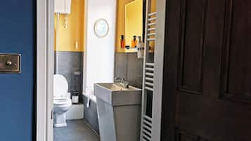 A compact bathroom with a toilet, sink, and towel rack.
