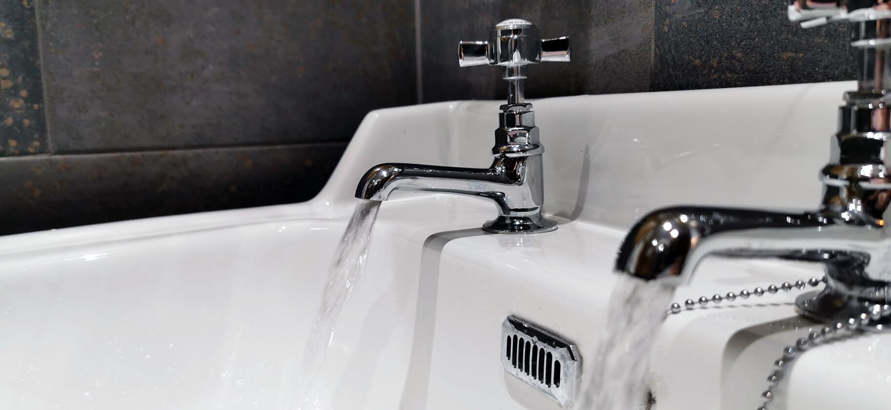 A bathroom sink with a chrome faucet and a water drain.
