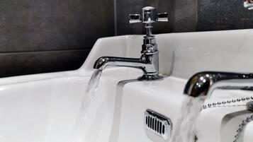 A bathroom sink with a chrome faucet and a water drain.