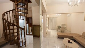 A modern living room with a spiral staircase, a dining area, and a chandelier. - Acropolis view! (Athina)