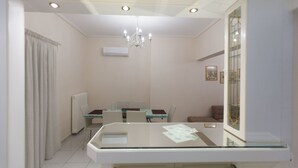 A modern hotel room with a glass dining table, a chandelier, and a large mirror. - Acropolis view! (Athina)