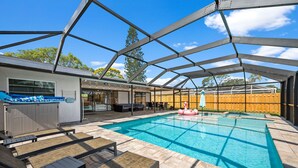 An outdoor swimming pool with a covered patio area, lounge chairs, and a barbecue setup. - The Shiny Diamond in Sarasota. 10 minutes to SIESTA BEACH (Sarasota)