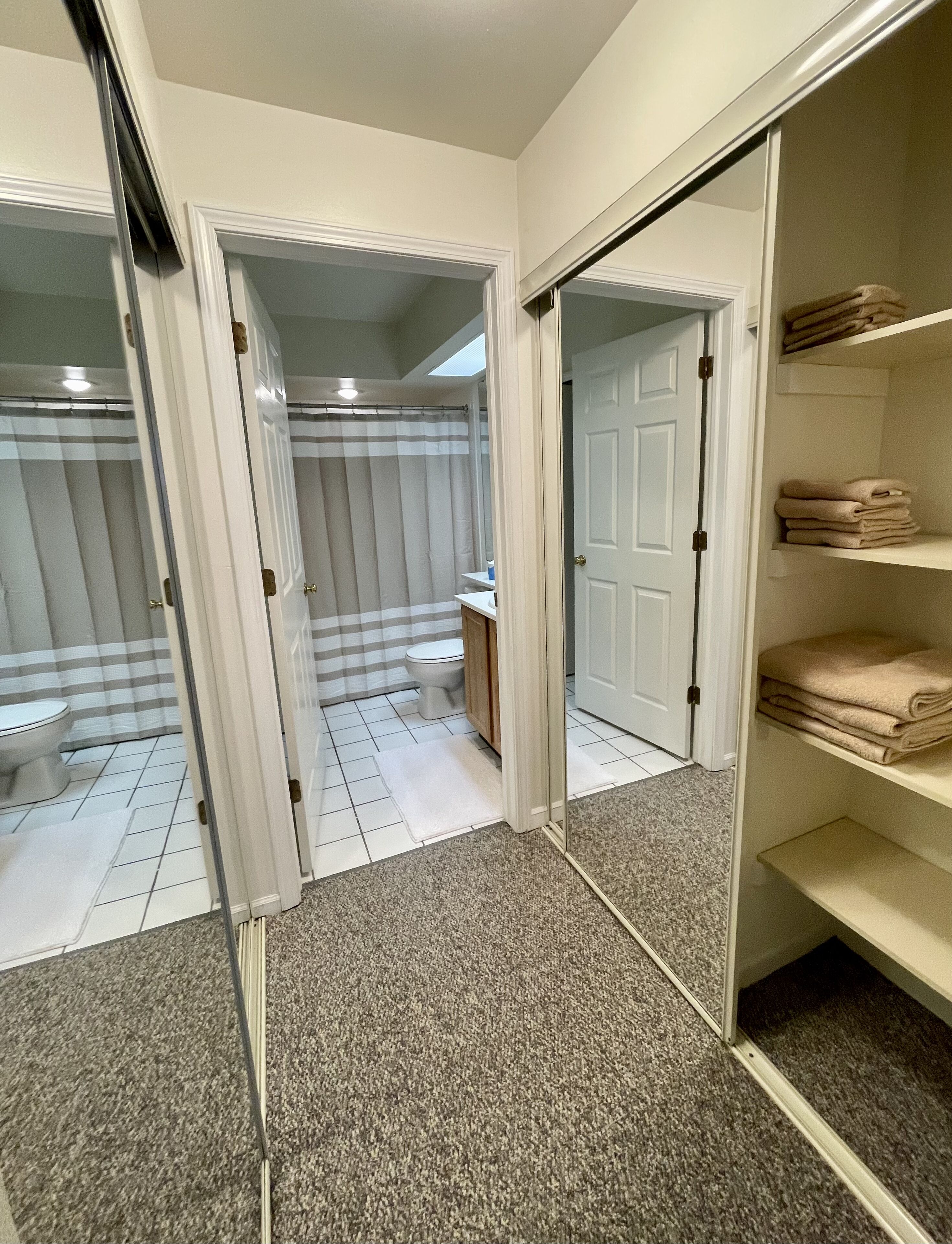 Ein Badezimmer mit Toilette, Duschvorhang und Handtuchhalter.
