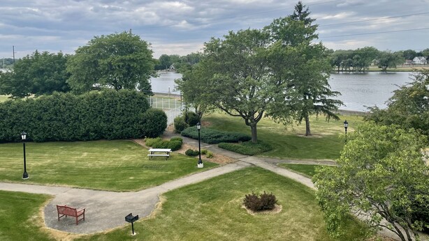 A park with a picnic table, benches, and a walking path. - The Alex Furnished Rentals (Oshkosh)