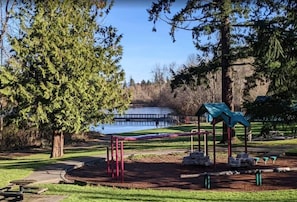 Enjoy a peaceful retreat amidst lush greenery and a serene body of water, surrounded by a playground and picnic areas.