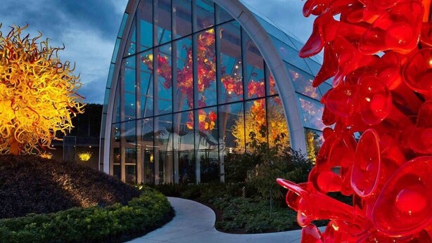 A modern building with a curved glass facade and a pathway leading to it. - Amazing Courtyard View DT Parking tub pool 99 WS (Seattle)