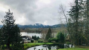 A lakeside property with a house, a pond, and surrounding greenery. - Elegant 4400sf Villa w/ Lk. & Mt. view | Sammamish (Sammamish)