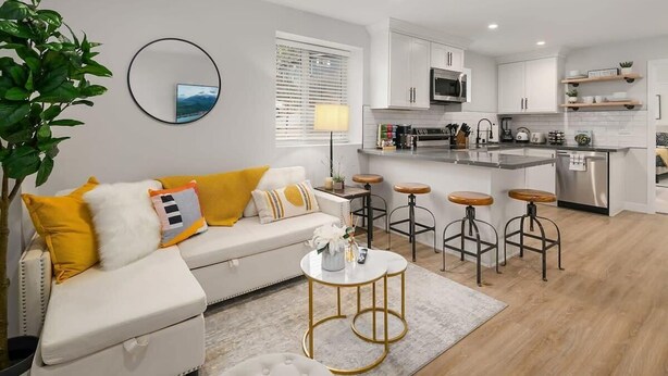 A modern kitchen with white cabinets, a stainless steel microwave, and a built-in oven. - Brand New Designer's Modern, 1BR Home 1min to I-5 (Lynnwood)