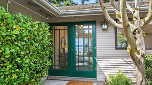 A house with a green door, a small porch, and a tree with moss. - Family Retreat w Lake & Mt & City View, Gym, MI (Mercer Island)