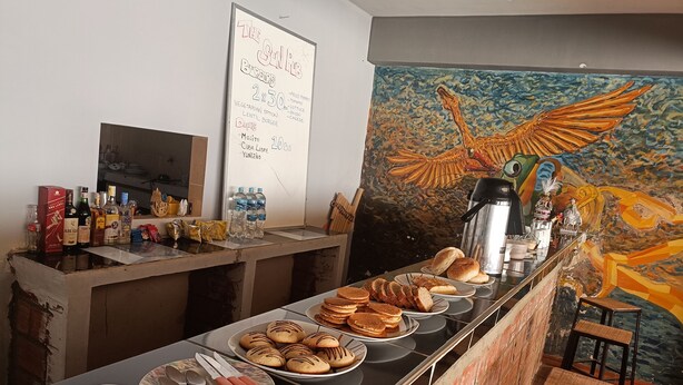 A breakfast buffet with various food items, a coffee station, and a mural on the wall. -  Solsticio Copacabana (Copacabana)