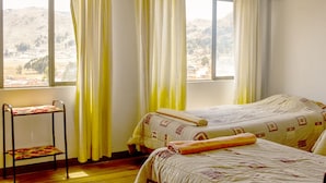 A room with two beds, a small table, and large windows with curtains. -  Solsticio Copacabana (Copacabana)