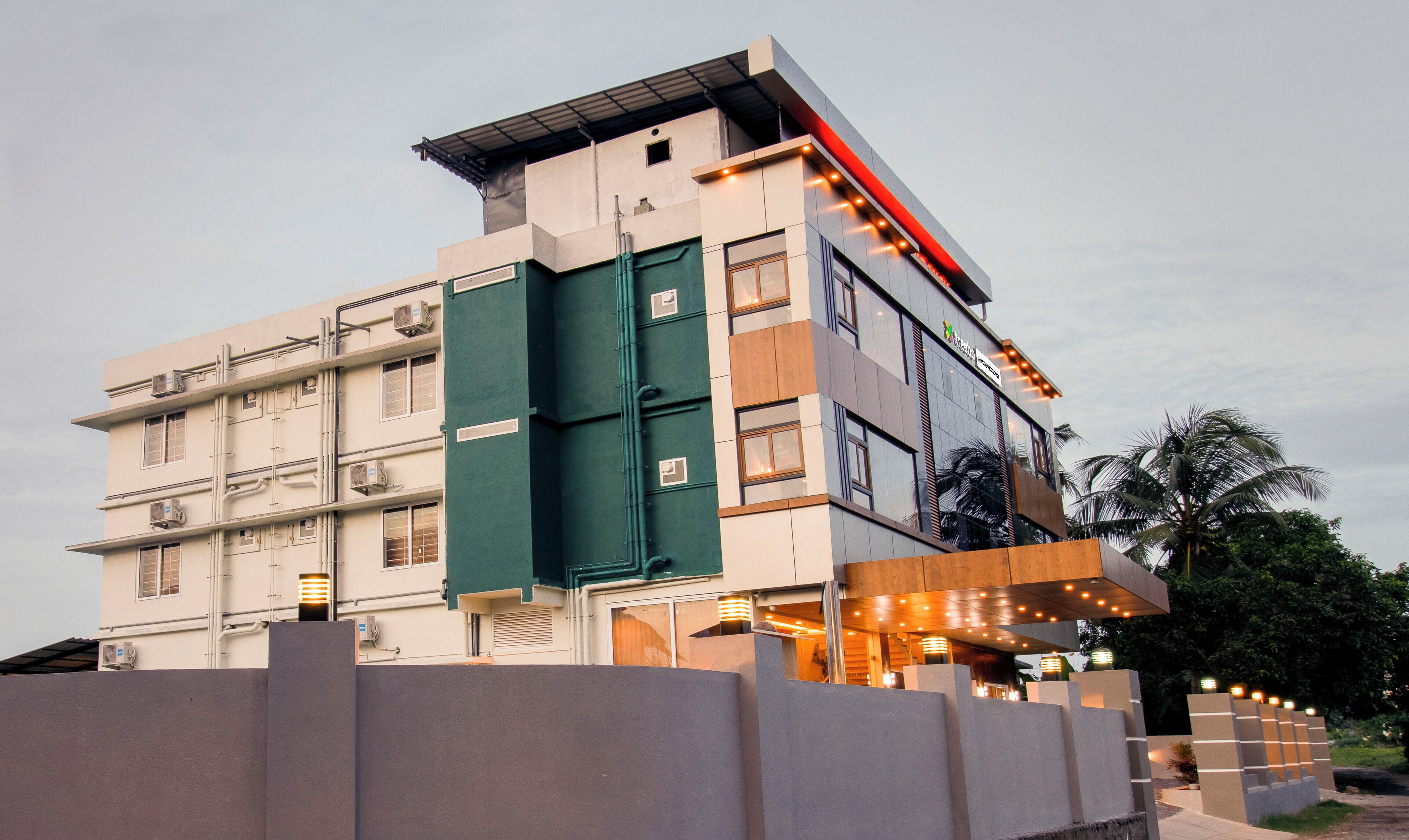 A multi-story hotel with a flat roof, large windows, and a green door.