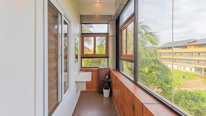 A balcony with a view of a building and greenery. - Treebo Amigos Residency Cochin Airport Hotel (Aluva)