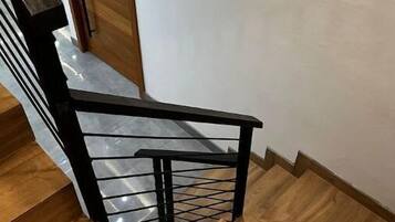 Una escalera de madera con barandilla de metal negro.