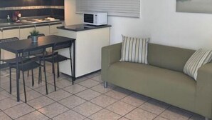 A compact living space with a kitchenette, a dining area, and a sofa.