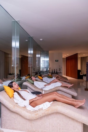 A spa room with massage chairs, a large mirror, and a modern interior design.