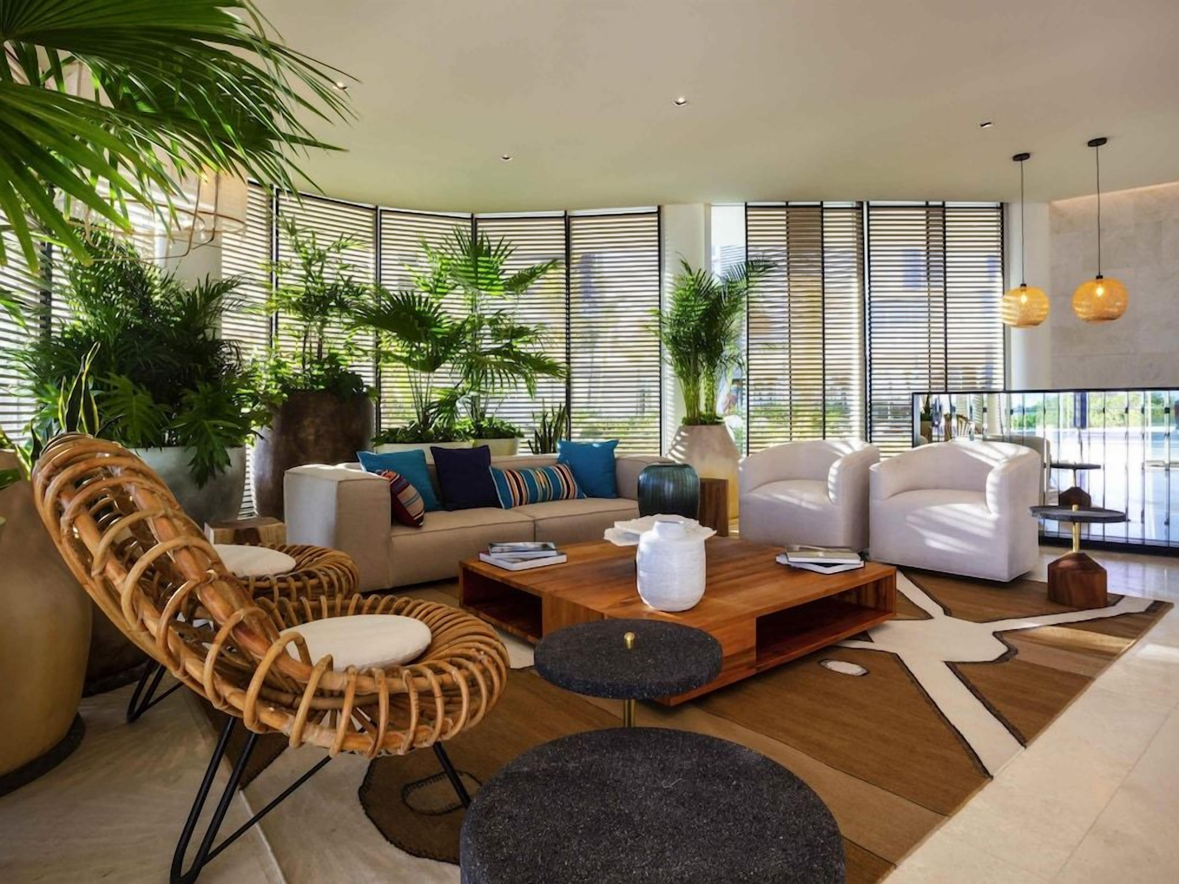 A modern living room with a sofa set, a coffee table, and a large window with blinds.