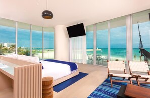 Une chambre d’hôtel avec un lit, une télévision, un balcon donnant sur la plage et un hamac.