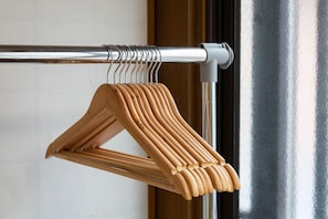 Un perchero de metal con perchas de madera.