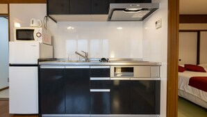 A compact kitchen with a microwave, coffee maker, and built-in oven. - Yoneyama 2F (Osaka)