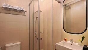 Ein Badezimmer mit Duschkabine, Waschbecken in Weiß und Toilette.