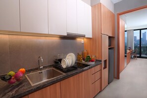 A modern kitchen with a stainless steel sink, wooden cabinets, and a built-in oven.