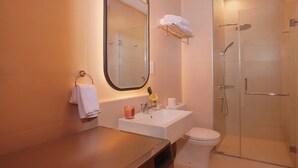Ein Badezimmer mit Waschbecken, Spiegel, Toilette und einer Duschkabine.