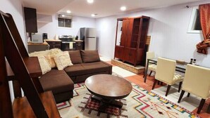 A compact living space with a sofa set, a dining table with chairs, a kitchen area, and a cabinet. - FIFA! Industrial Boho Haven: Private Space near DC (Alexandria)