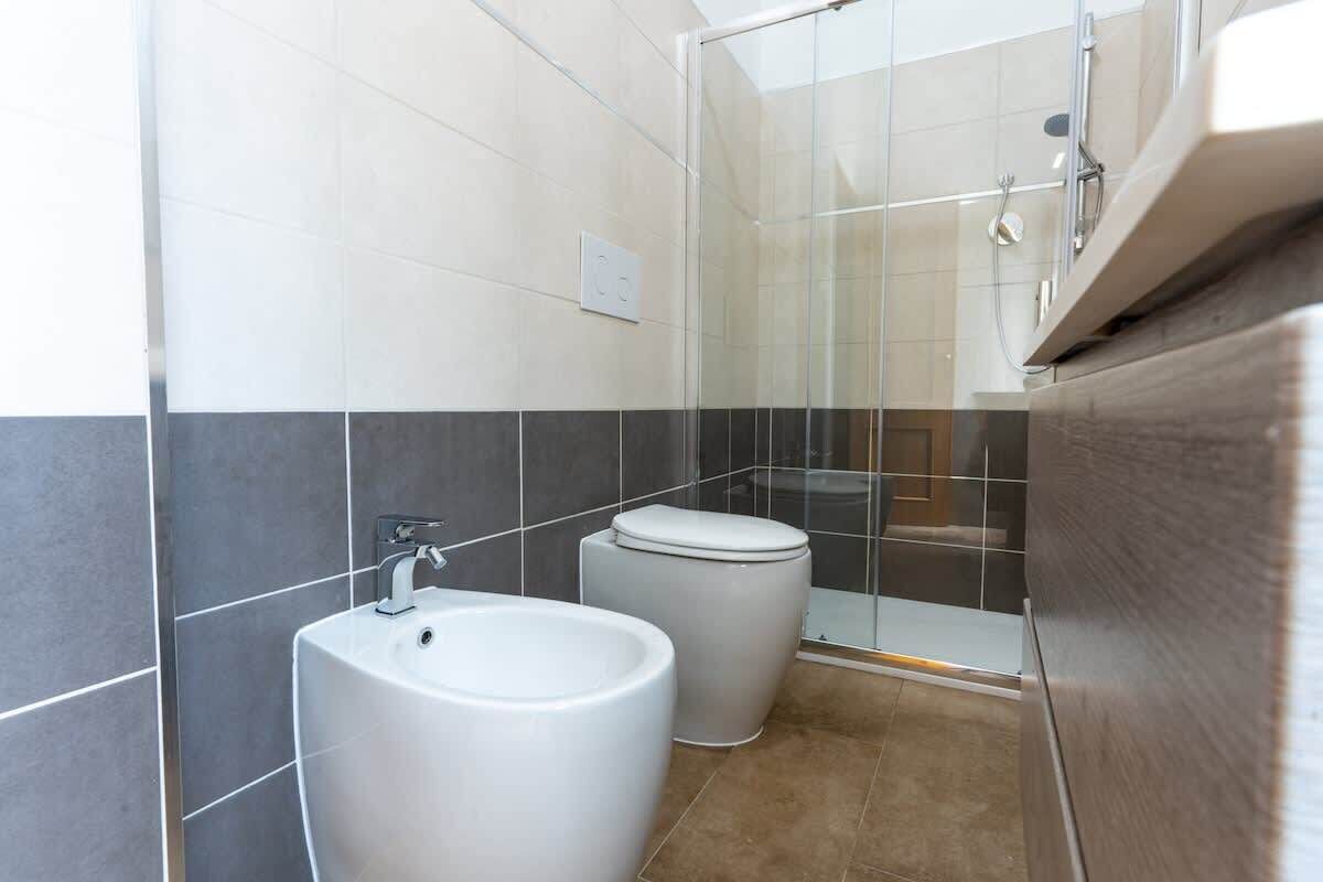 A bathroom with a sink, toilet, and glass shower enclosure.