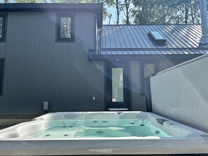 Ein Whirlpool in einer Außenanlage, im Hintergrund ein Haus.