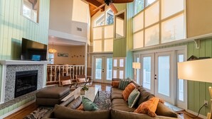 A spacious living room with a large sectional sofa, a fireplace, and a ceiling fan. - Waterfront Retreat + Kayaks - Extended Stay Deal (Spring Hill)