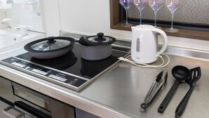 A kitchen with an induction cooktop, a kettle, and a set of cooking utensils. - Yoneyama 4F (Osaka)