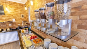 A buffet setup with various food items and drink dispensers. - Pousada Maresias Beira Mar (São Sebastião)