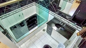 A modern bathroom with a glass shower enclosure, a black sink, and a white tiled floor. - Casa com Piscina e Churrasqueira (Foz do Iguaçu)