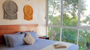 Ein Schlafzimmer mit einem großen Bett, einem hölzernen Kopfteil und zwei Wandbildern.