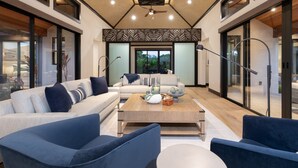 A spacious living room with a large sofa, two armchairs, a coffee table, and a ceiling fan. - Luxury Nohea Home w/ Pool & private 2 BR Ohana
Access to Mauna Lani Sports Club! (Kamuela)