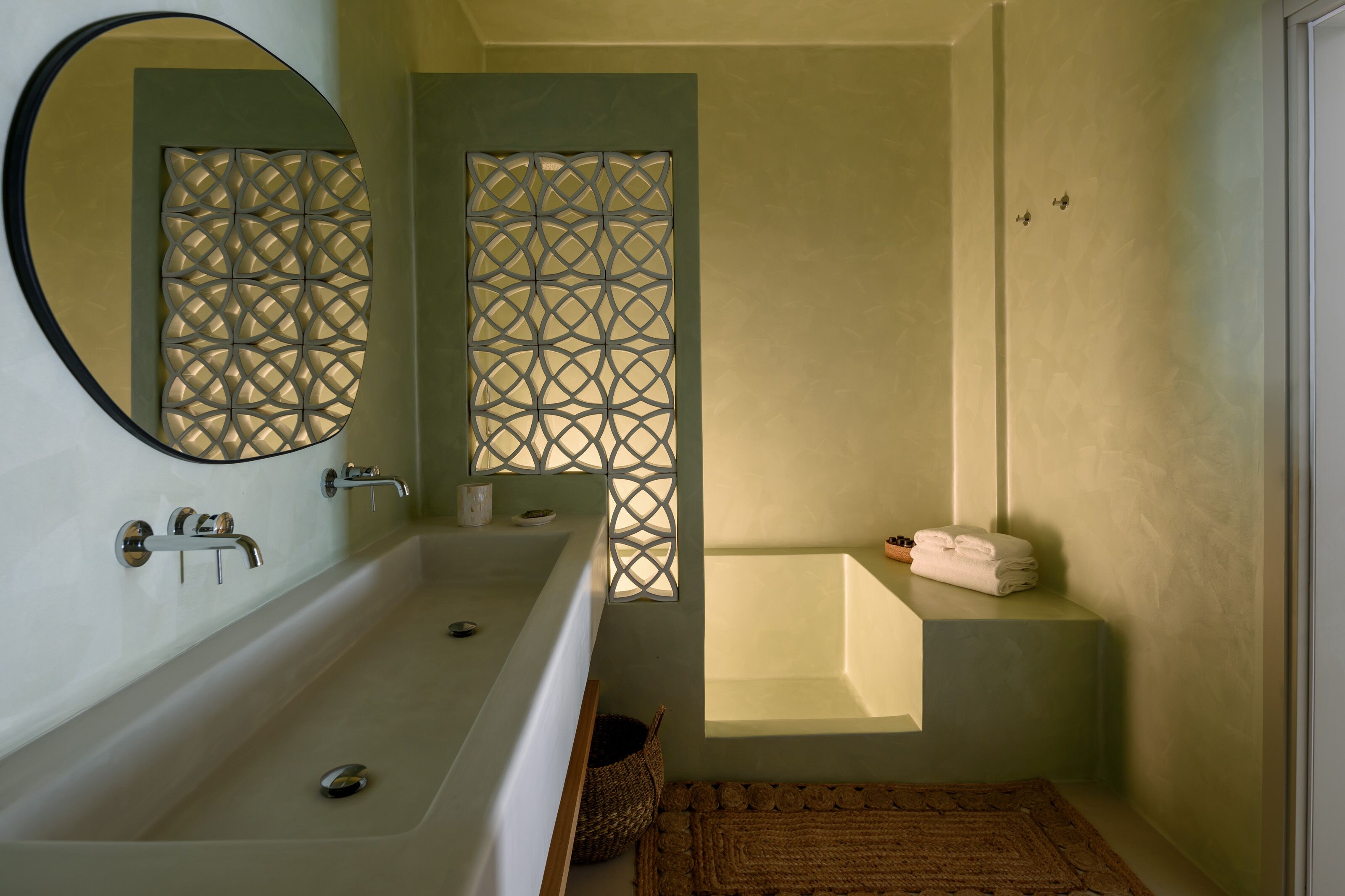 A bathroom with a freestanding bathtub, a large mirror, and a decorative screen.